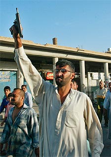 Un habitante de Bagdad dispara al aire, ayer en el entierro de un jeque local.