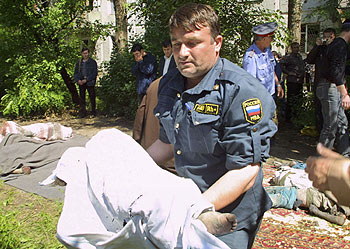 Un policía lleva en brazos el cadáver de un niño muerto en la explosión.