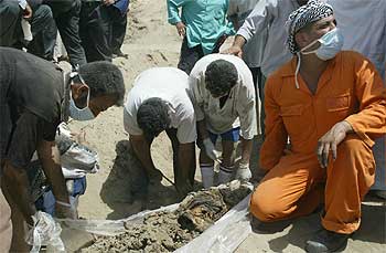 Un grupo de voluntarios exhuma los restos de un cadáver en la fosa común hallada en Madaen, a 30 kilómetros de Bagdad.