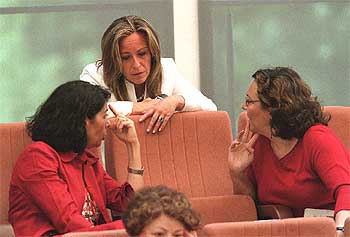 Trinidad Jiménez (concejal electa del PSOE), de pie, conversa con Inés Sabanés, de IU (a la izquierda), durante el pleno de ayer.