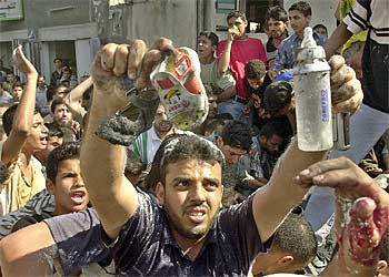 Un palestino muestra zapatos de una niña muerta ayer en el ataque israelí contra un líder de Hamás en Gaza.