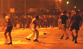Un ultranacionalista arrojando piedras a la policía en la madrugada del viernes, en Belgrado.