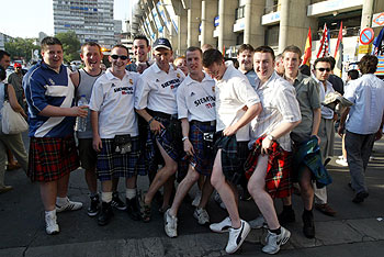 Un grupo de aficionados con faldas escoceses a las puertas del Bernabéu.rnrnUna niña con la camiseta de Raúl, un seguidor camuflado con prendas madridistas y la llegada del autobús del Madrid entre una marea de hinchas.