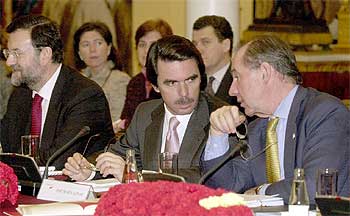 El presidente del Gobierno, José María Aznar, flanqueado por Mariano Rajoy y Rodrigo Rato (a la derecha), en una reunión oficial.