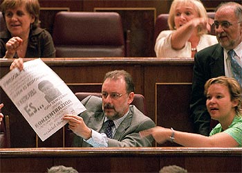 Álvaro Cuesta muestra a Aznar un cartel con amenazas recibidas por un dirigente socialista navarro.