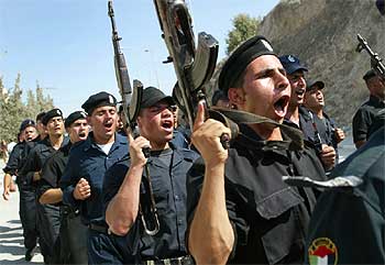 Policías palestinos cantan mientras se dirigen a patrullar las calles de Belén, tras la retirada israelí.