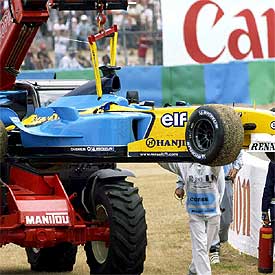 Las asistencias retiran el coche averiado de Fernando Alonso.
