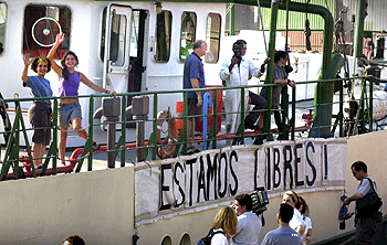 Tripulantes del  Rainbow Warrior  saludaban ayer al zarpar el barco del puerto de Valencia.