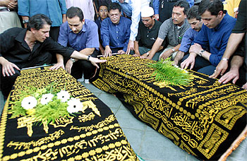 Miembros de la comunidad iraní en Singapur rezan ante los féretros de las hermanas Bijani.