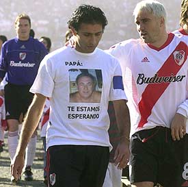 Astrada, con una camiseta alusiva al secuestro de su padre, junto a Coudet, el domingo 6, día de su retirada.
