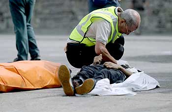 Un agente inspecciona el cadáver de uno de los inmigrantes que murieron ayer ahogados en aguas de Tarifa.