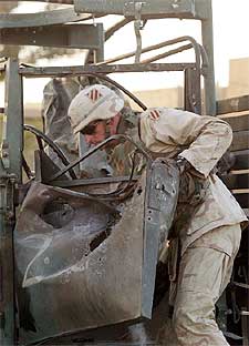 Un soldado de la Tercera División de EE UU inspecciona un vehículo atacado.
