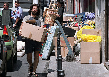 Dos  okupas   trasladan objetos desde el edificio desalojado por la policía en la calle de Santa María. 
