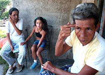 María Acosta, a la derecha, señala en La Coloma por dónde entró la bala con la que se suicidó su hijo.