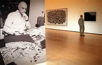 Antonio Saura (a la izquierda) y una vista de la exposición del Guggenheim con los cuadros  Karl Johann II  y  Retrato imaginario de Goya .