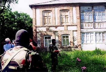 Francisco Rodríguez (izquierda), protegido por agentes especiales, identifica uno de los  zulos.  Abajo, Rodríguez, en la zona donde le secuestraron.