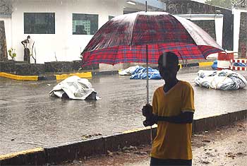 Un hombre pasa junto a varios cadáveres en una calle de la capital liberiana, Monrovia.