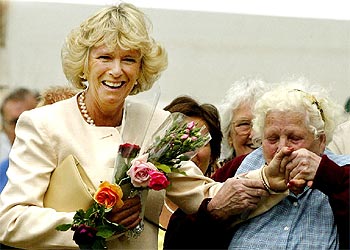Camilla Parker sonríe mientras Dorothy Edwards, de 77 años, le besa la mano, ayer, en Sandringham.
