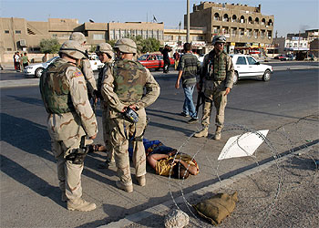 Policías militares de EE UU vigilan a un iraquí detenido por robo en el centro de Bagdad.