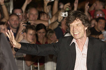 Mick Jagger saluda a las personas que le aclamaron a la entrada del club donde se celebró la fiesta.