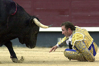 Rafaelillo intenta evitar la embestida del toro.