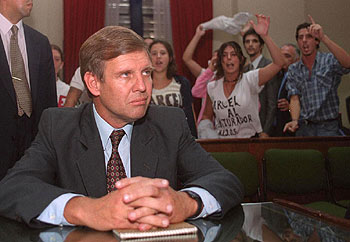 El ex capitán Alfredo Astiz espera el inicio de un juicio en 2000 en Buenos Aires, ante las protestas de un grupo de jóvenes.