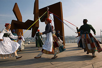 Un grupo de jóvenes baila ante la escultura  Construcción vacía  de Oteiza, en San Sebastián.