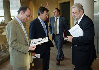El diputado tránsfuga Eduardo Tamayo pasa tras el grupo en el que conversa el popular Antonio Beteta.