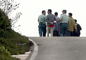 La Guardia Civil traslada a inmigrantes detenidos tras haber huido del centro de acogida de Tarifa.