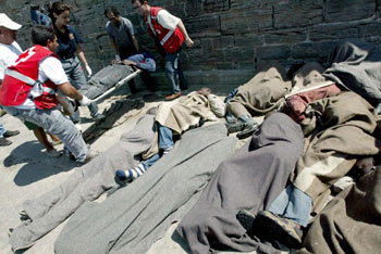 Miembros de Cruz Roja de Tarifa trasladan a uno de los inmigrantes que se encontraba enfermo.