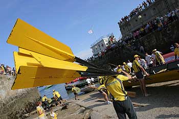 Un tripulante de Orio lleva los remos a su trainera, en la bocana del puerto de San Sebastián, antes de la regata.