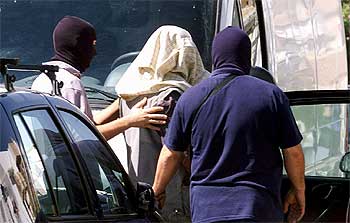 Momento en el que la policía detenía ayer en Granada al sirio Hamal Hussein Hussein, en el centro, con la cabeza cubierta.