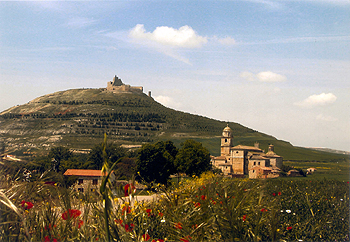 A la entrada de Castrojeriz (Burgos) aparece la mole de la antigua colegiata de la Virgen del Manzano, y sobre la colina la silueta de las ruinas del castillo.