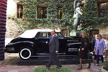 El Rey, la infanta Cristina y la ministra de Cultura pasan ante el Cadillac que preside el patio del Museo Dalí de Figueres.
