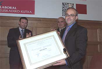 Gurutz Jáuregui tras recibir el diploma que acredita el premio concedido, ante el  lehendakari  Ibarretxe y Javier Retegi.