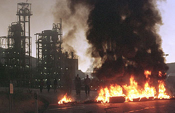 Un grupo de trabajadores de subcontratas cortan los accesos a Repsol con barricadas incendiadas.