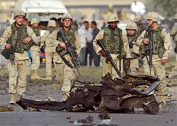 Soldados de EE UU observan los restos del coche bomba que explotó ayer junto a la Embajada turca en Bagdad.