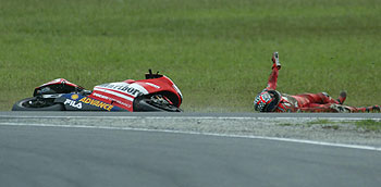 El norteamericano Troy Bayliss permanece en el suelo junto a su moto tras sufrir una caída que le dejó inconsciente durante unos instantes.