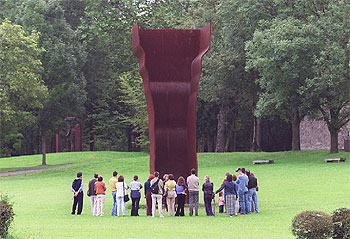 Un grupo de visitantes, ante la escultura   Buscando la luz I   (1998), en el Museo Chillida-Leku, en Hernani (Guipúzcoa).