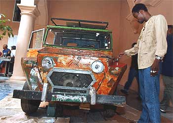 El artista Dominique Zinkpe, de Benin, junto a su obra  Taxi Bush,   en la Bienal d  e La Habana .