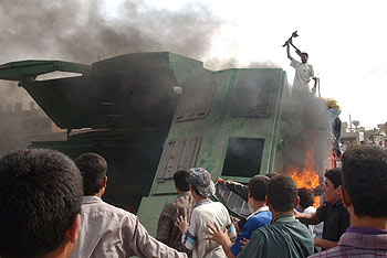 Iraquíes ante un camión quemado por transportar suministros para las tropas de EE UU, ayer en las afueras de Faluya.