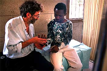 Un voluntario de Médicos del Mundo atiende a un inmigrante en los cuarteles de Sant Andreu de Barcelona.