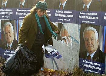 Un trabajador recoge restos de propaganda electoral del candidato Dragoljub Micunovic.