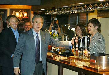 Bush agarra un grifo de cerveza en un  pub  de Sedgfield, feudo de Blair, que aparece tras el presidente de EE UU.