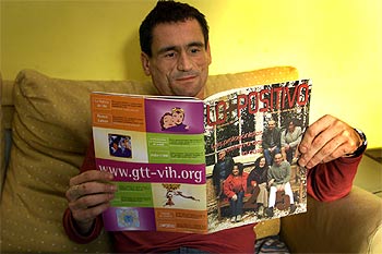 Xavier Franquet lee  Lo + positivo,  la revista sobre sida en la que trabaja, en su casa de Barcelona.