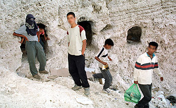 Menores marroquíes, ante la cueva en la que viven en los acantilados de Melilla.