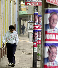 Un guatemalteco pasa junto a unos carteles electorales de Berger.