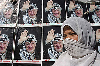 La madre de un palestino preso en una cárcel israelí pasa ante imágenes de Arafat ayer en una manifestación en Gaza.