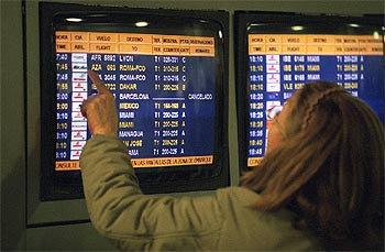 Una viajera observa las pantallas del aeropuerto de Barajas durante la jornada de ayer.