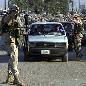 Un soldado estadounidense y un miembro de la Defensa Civil iraquí, ayer, en un puesto de control en Bagdad.